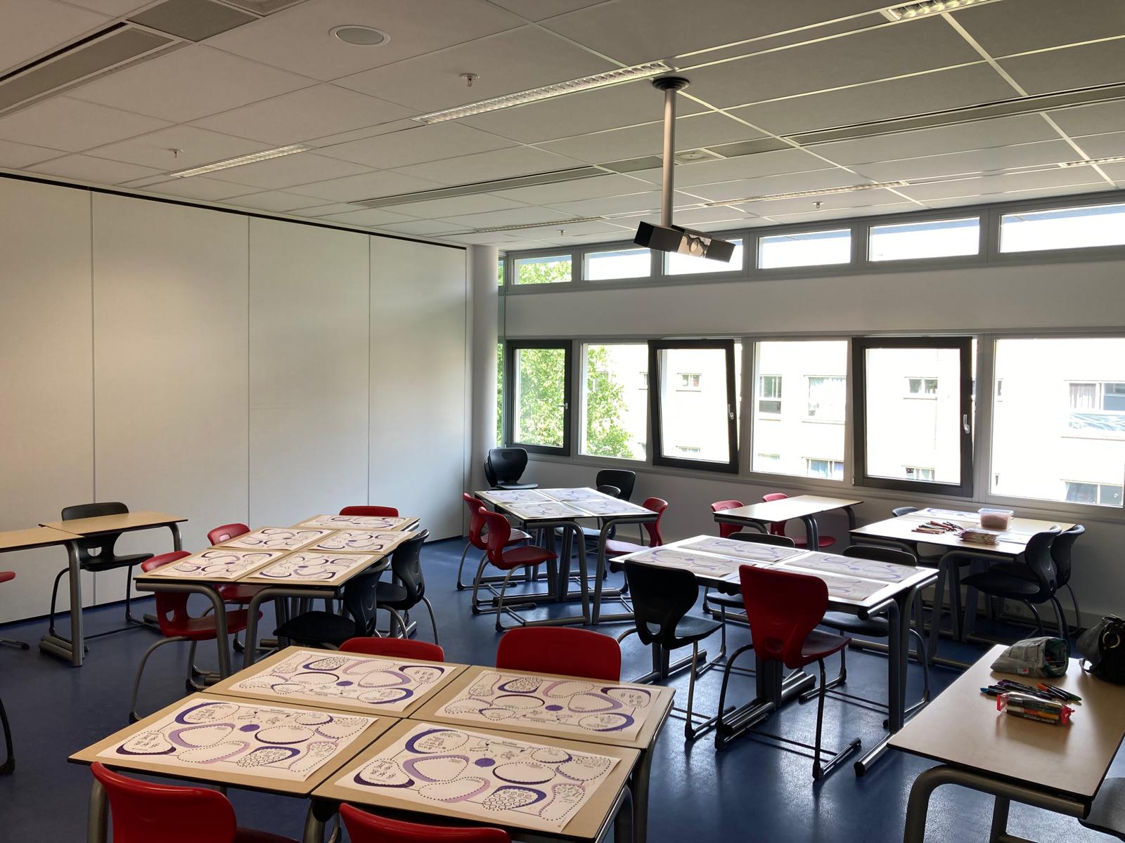 Leslokaal met werkbladen en markers klaargelegd voor een workshop visueel communiceren